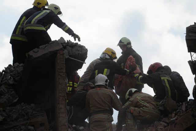 Rescuers carry the body of a child they recovered from the rubble during a search and rescue operation carried out at the site of a Russian airstrike that hit a multi-storey residential building in Pryluky on October 7, 2026, amid the Russian invasion of Ukraine. (Photo by Genya SAVILOV / AFP)