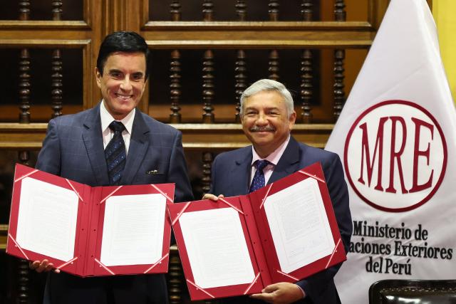 Peruvian Foreign Minister Carlos Espa (L) and Culture Minister Alberto Beingolea display the transfer document for 342 cultural artefacts repatriated from six countries and handed over to the Ministry of Culture during a ceremony at the Foreign Ministry headquarters in Lima on October 7, 2026. (Photo by Connie FRANCE / AFP)
