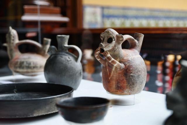 A Vicus-style bottle is displayed alongside other cultural artefacts voluntarily returned to the Embassy of Peru in the United Kingdom and Northern Ireland during a ceremony marking the handover of 342 cultural artefacts repatriated from six countries to Peru's Ministry of Culture, at the Foreign Ministry headquarters in Lima on October 7, 2026. (Photo by Connie FRANCE / AFP)