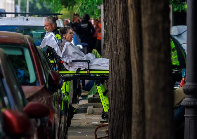 Maricarmen Abascal, an 87-year-old pensioner, is taken on a stretcher as she was evicted from her Madrid home, on September 23, 2026. Abascal, whose eviction triggered nationwide protests over Spain's chronic housing crisis and a political debate that culminated in early elections died on Wednesday, a tenants' union said. Abascal became a symbol of Spain's housing market on September 23 when she was evicted from her life-long Madrid home on a stretcher after the real estate firm that owned the apartment drastically hiked the rent. (Photo by DANI DUCH / LA VANGUARDIA / AFP) / Spain OUT / MANDATORY CREDIT "DANI DUCH - LA VANGUARDIA"