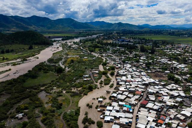 This aerial view shows a flooded area following the overflow of the Mapocho River in Talagante, Metropolitan Region, Chile, on October 7, 2026. Chile's national disaster prevention and response service (SENAPRED) declared on October 6, 2026 a yellow alert for the Metropolitan Region due to the heavy rainfall in the capital. (Photo by Javier TORRES / AFP)