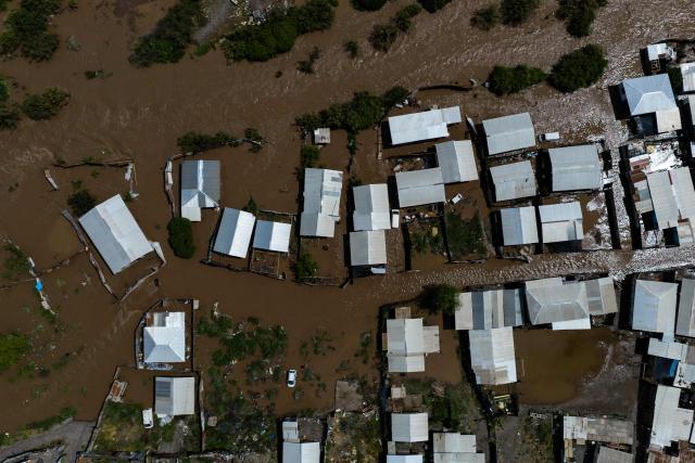 This aerial view shows a flooded area following the overflow of the Mapocho River in Talagante, Metropolitan Region, Chile, on October 7, 2026. Chile's national disaster prevention and response service (SENAPRED) declared on October 6, 2026 a yellow alert for the Metropolitan Region due to the heavy rainfall in the capital. (Photo by Javier TORRES / AFP)