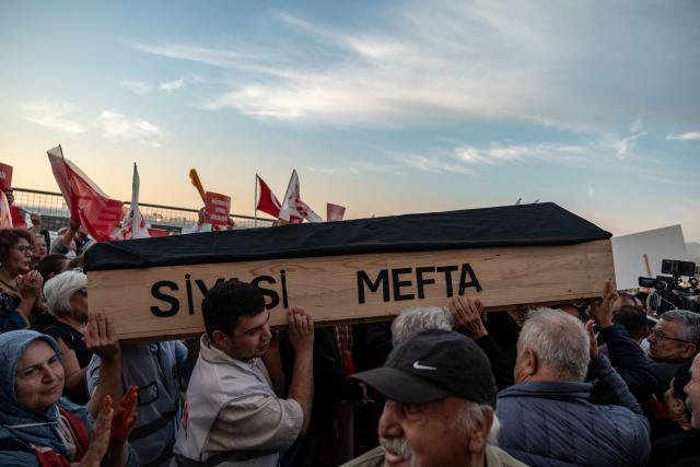 People carry a coffin bearing the words "political corpse" during a demonstration to protest against Izmir mayor Cemil Tugay's defection to the ruling AKP party, in Izmir on October 7, 2026. More than 1,000 protesters gathered in Turkish opposition stronghold Izmir on Ocotber 6, 2026, angered by the defection of the city's mayor to President Recep Tayyip Erdogan's ruling AKP. The move was a huge symbolic victory for the Turkish leader, who has long wanted to control the secular resort city of 4.5 million people on Turkey's Aegean coast which has been held by the opposition for nearly 30 years. (Photo by Murat Kocabas / AFP)