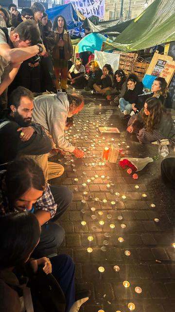 People gather and light candles at an impromptu vigil in the Puerta del Sol after learning that Maricarmen Abascal, the 87-year-old pensioner whose eviction triggered nationwide protests over Spain's chronic housing crisis and a political debate that culminated in early elections, had died in hospital in Madrid on October 7, 2026. Abascal became a symbol of Spain's housing market on September 23 when she was evicted from her life-long Madrid home on a stretcher after the real estate firm that owned the apartment drastically hiked the rent. (Photo by Maria Lorente / AFP)