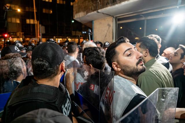Turkish riot police officers push back protesters demonstrating against Izmir mayor Cemil Tugay's defection to the ruling AKP party, in Izmir on October 7, 2026. More than 1,000 protesters gathered in Turkish opposition stronghold Izmir on October 7, 2026, angered by the defection of the city's mayor to President Recep Tayyip Erdogan's ruling AKP. The move was a huge symbolic victory for the Turkish leader, who has long wanted to control the secular resort city of 4.5 million people on Turkey's Aegean coast which has been held by the opposition for nearly 30 years. (Photo by Murat Kocabas / AFP)