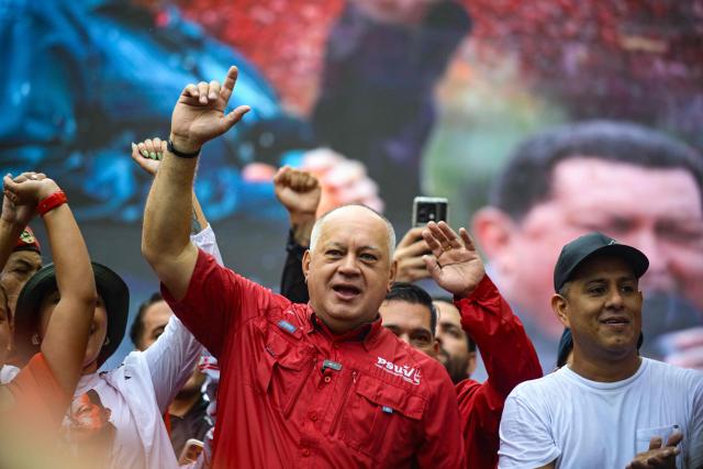Venezuela's Minister of Interior, Justice and Peace Diosdado Cabello (C) takes part in a march marking the anniversary of late president Hugo Chavez's final electoral victory in 2012, in Caracas on October 7, 2026. (Photo by Maxwell BRICENO / AFP)