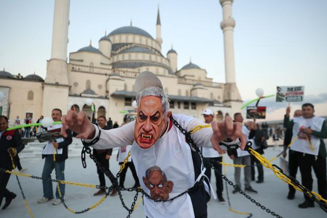 A protester wears a mask depicting Israeli Prime Minister Benjamin Netanyahu during a pro-Palestinian march in Ankara on October 7, 2026 on the third anniversary of Hamas' 2023 attacks against Israel known as "Operation Aqsa Flood". (Photo by ADEM ALTAN / AFP)