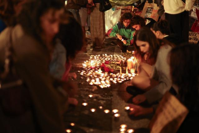 People gather for a vigil in the Puerta del Sol after learning that Maricarmen Abascal, the 87-year-old pensioner whose eviction triggered nationwide protests over Spain's chronic housing crisis and a political debate that culminated in early elections, had died in hospital in Madrid on October 7, 2026. Abascal became a symbol of Spain's housing market on September 23 when she was evicted from her life-long Madrid home on a stretcher after the real estate firm that owned the apartment drastically hiked the rent. (Photo by Thomas COEX / AFP)