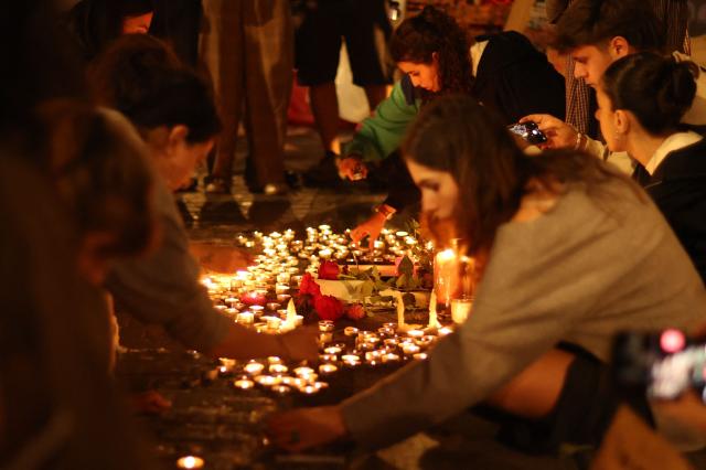 People gather for a vigil in the Puerta del Sol after learning that Maricarmen Abascal, the 87-year-old pensioner whose eviction triggered nationwide protests over Spain's chronic housing crisis and a political debate that culminated in early elections, had died in hospital in Madrid on October 7, 2026. Abascal became a symbol of Spain's housing market on September 23 when she was evicted from her life-long Madrid home on a stretcher after the real estate firm that owned the apartment drastically hiked the rent. (Photo by Thomas COEX / AFP)