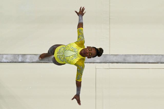 (FILES) An overview shows Brazil's Rebeca Andrade competing in the balance beam event of the artistic gymnastics women's all around final during the Paris 2024 Olympic Games at the Bercy Arena in Paris, on August 1, 2024. Brazilian Olympic champion Rebeca Andrade will return to competition at the artistic gymnastics world championships after missing last year's edition during a career break taken for mental health reasons, the country's gymnastics confederation said on October 7, 2026. (Photo by Martin BUREAU / AFP)