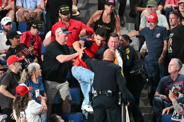 A protester is restrained by Sheriff deputies and supporters of US President Donald Trump as the president speaks during a campaign rally at the Freeman Coliseum in San Antonio, Texas, on October 7, 2026. Republican Senate candidate Ken Paxton is in a close race with Democratic candidate James Talarico for one of Texas' US Senate seats. (Photo by Mandel NGAN / AFP)