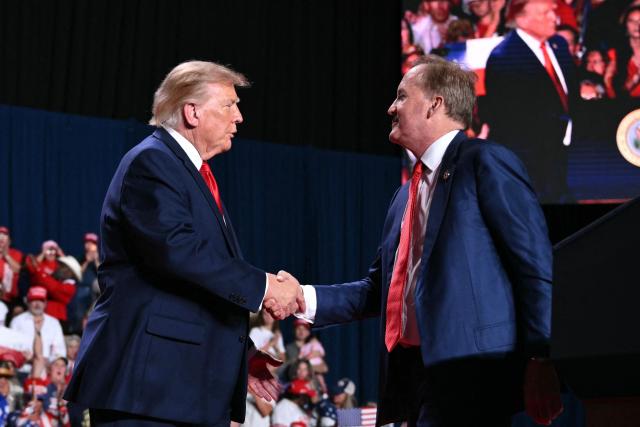 US President Donald Trump (L) shakes hands with Republican candidate for US Senate Ken Paxton (R) during a campaign rally at the Freeman Coliseum in San Antonio, Texas, on October 7, 2026. Republican Senate candidate Ken Paxton is in a close race with Democratic candidate James Talarico for one of Texas' US Senate seats. (Photo by Mandel NGAN / AFP)