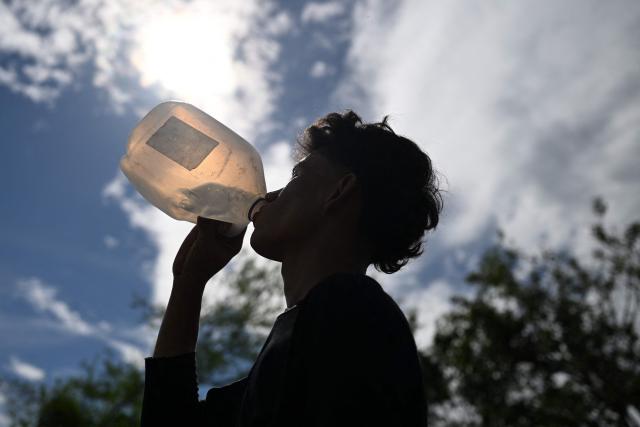 (FILES) A farmer drinks water during a break while cutting a corn crop ruined by the lack of rainfall in Tecoluca, San Vicente department, El Salvador, on August 26, 2026. El Salvador is preparing for the risk that an El Nino-linked drought could affect food production and supplies, after Congress on October 7, 2026 approved a six-month national emergency plan, lawmakers announced. (Photo by Marvin RECINOS / AFP)