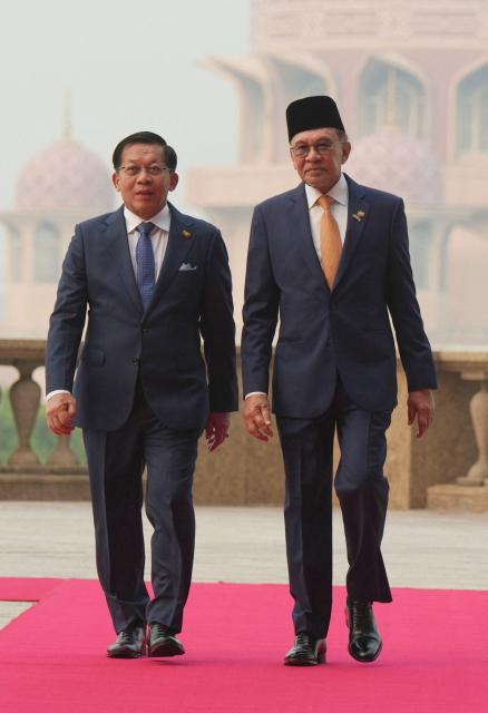 Myanmar’s President Min Aung Hlaing (L) walks with Malaysia’s Prime Minister Anwar Ibrahim during a welcome ceremony at the prime minister’s office in Putrajaya on October 8, 2026. (Photo by Azneal Ishak / POOL / AFP)