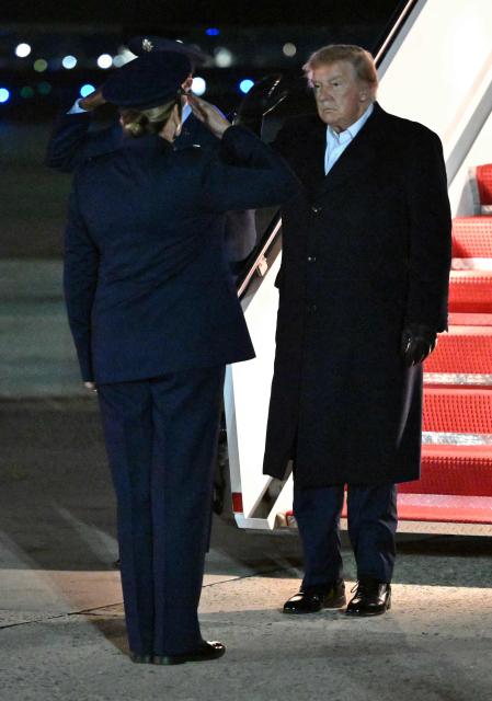 US President Donald Trump salutes after stepping off Air Force One upon arrival at Joint Base Andrews, Maryland in the early hours of October 8, 2026. Trump is returning from San Antonio, Texas where he spoke at a midterm elections campaign rally. (Photo by Mandel NGAN / AFP)