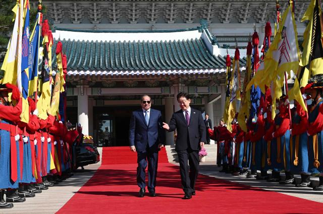 Egypt's President Abdel Fattah El-Sisi (L) and South Korea's President Lee Jae Myung (R) attend a welcome ceremony at the presidential Blue House in Seoul on October 8, 2026. (Photo by JUNG YEON-JE / POOL / AFP)