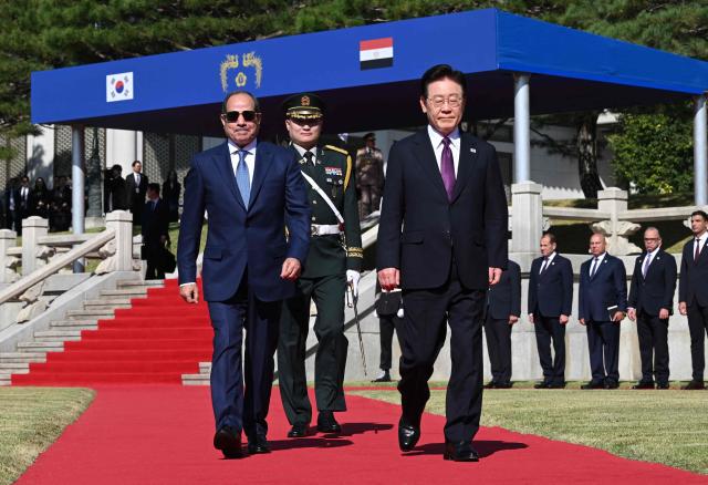 Egypt's President Abdel Fattah El-Sisi (L) and South Korea's President Lee Jae Myung (R) attend a welcome ceremony at the presidential Blue House in Seoul on October 8, 2026. (Photo by JUNG YEON-JE / POOL / AFP)