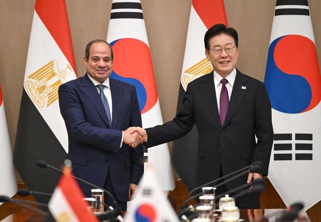 Egypt's President Abdel Fattah El-Sisi (L) shakes hands with South Korea's President Lee Jae Myung (R) during their meeting at the presidential Blue House in Seoul on October 8, 2026. (Photo by JUNG YEON-JE / POOL / AFP)