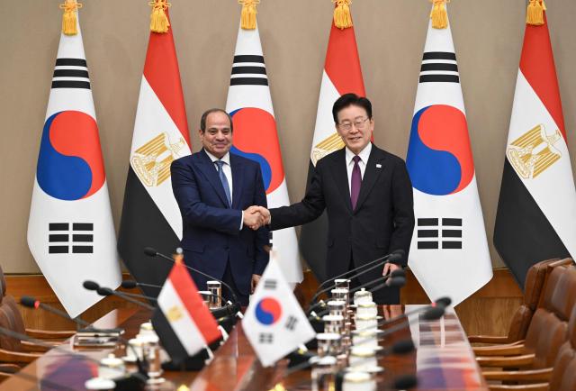 Egypt's President Abdel Fattah El-Sisi (L) shakes hands with South Korea's President Lee Jae Myung (R) during their meeting at the presidential Blue House in Seoul on October 8, 2026. (Photo by JUNG YEON-JE / POOL / AFP)