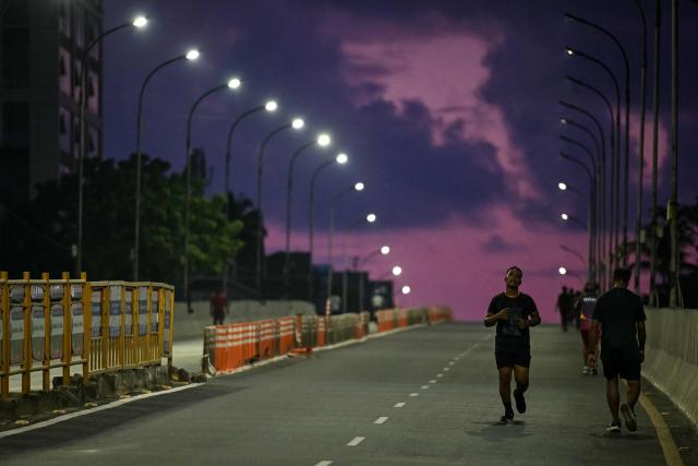 A man jogs early in the morning on a flyover in Chennai on October 8, 2026. (Photo by R. Satish BABU / AFP)