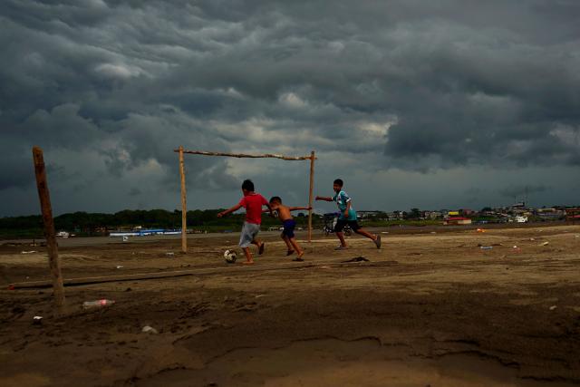 TOPSHOT - Children play football on the banks of the Amazon River in Santa Rosa de Yavari, Peru, on October 7, 2026. (Photo by Pablo VERA / AFP)