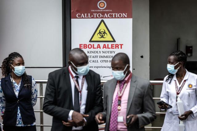 Hospital staff gather at the entrance of an isolation facility marked with an Ebola alert sign at Nairobi Hospital in Nairobi on October 7, 2026. Kenya has reported its first-ever Ebola death, the health minister announced on October 6, 2026, after a Kenyan man who had been living in the Democratic Republic of Congo died after returning to the country. (Photo by Luis TATO / AFP)