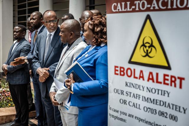 Kenya's Cabinet Secretary for Health Aden Duale (3rd L) looks on as senior health officials address the media outside an isolation facility marked with an Ebola alert sign at Nairobi Hospital in Nairobi on October 7, 2026. Kenya has reported its first-ever Ebola death, the health minister announced on October 6, 2026, after a Kenyan man who had been living in the Democratic Republic of Congo died after returning to the country. (Photo by Luis TATO / AFP)