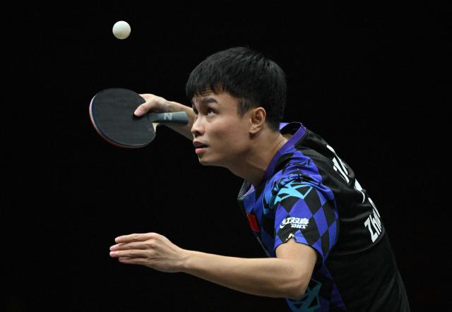 China’s Zhou Qihao serves to Japan’s Tomokazu Harimoto during their men’s singles match at the WTT China Smash table tennis tournament in Beijing on October 8, 2026. (Photo by ADEK BERRY / AFP)