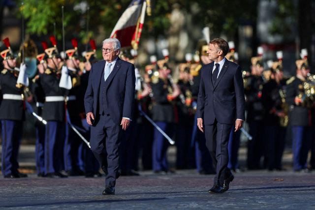 Germany's President Frank-Walter Steinmeier (L) and France's President Emmanuel Macron (R) attend a welcome ceremony as part of the German President's state visit to France, at The Tomb of the Unknown Soldier at L'Arc de Triomphe in Paris on October 8, 2026. (Photo by Abdul Saboor / POOL / AFP)