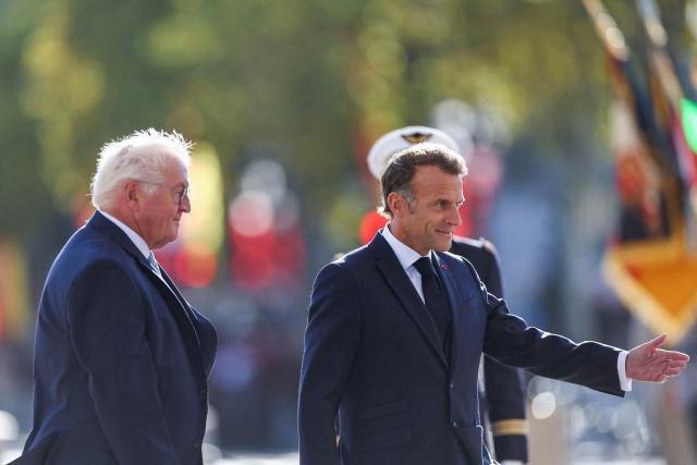 Germany's President Frank-Walter Steinmeier (L) and France's President Emmanuel Macron (R) attend a ceremony at The Tomb of the Unknown Soldier at L'Arc de Triomphe during a welcome ceremony as part of a state visit to France, in central Paris on October 8, 2026. (Photo by Abdul Saboor / POOL / AFP)