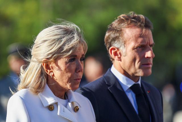 France's President Emmanuel Macron (R) and his wife Brigitte Macron arrive as they prepare to greet Germany's President and his wife as they arrive for a welcome ceremony at L 'Arc de Triomphe in Paris on October 8, 2026, as part of their state visit to France. (Photo by Abdul Saboor / POOL / AFP)