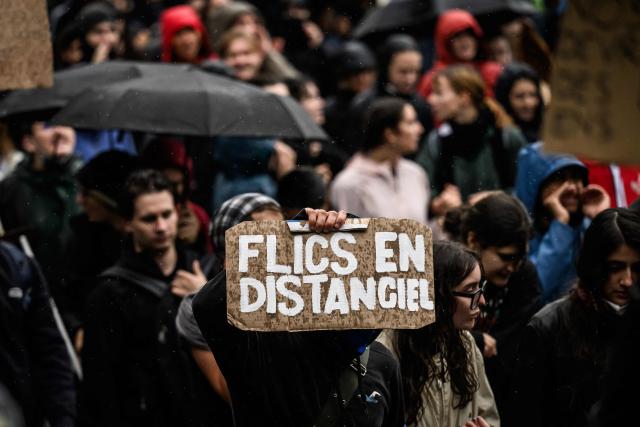 Protesters hold placards during a demonstration of high-school students in Bron, in the outskirts of Lyon, on October 8, 2026, as part of a nationwide protest movement over learning conditions. Since late September, pupils have barred the entrances to hundreds of schools, complaining of teacher absences, overloaded timetables, dilapidated classrooms and buildings ill-adapted to rising temperatures, among other grievances. (Photo by JEFF PACHOUD / AFP)