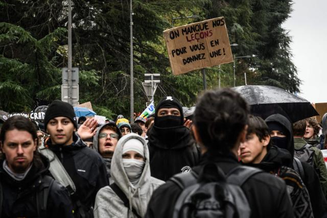 Protesters hold a placard reading "We’re missing our lessons so we can teach you one" during a demonstration of high-school students in Bron, in the outskirts of Lyon, on October 8, 2026, as part of a nationwide protest movement over learning conditions. Since late September, pupils have barred the entrances to hundreds of schools, complaining of teacher absences, overloaded timetables, dilapidated classrooms and buildings ill-adapted to rising temperatures, among other grievances. (Photo by JEFF PACHOUD / AFP)
