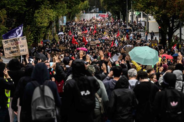 Protesters hold placards and banners during a demonstration of high-school students in Bron, in the outskirts of Lyon, on October 8, 2026, as part of a nationwide protest movement over learning conditions. Since late September, pupils have barred the entrances to hundreds of schools, complaining of teacher absences, overloaded timetables, dilapidated classrooms and buildings ill-adapted to rising temperatures, among other grievances. (Photo by JEFF PACHOUD / AFP)