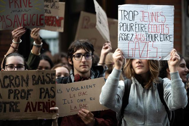Protesters hold placards during a blockade of private high-school Emilie de Rodat in Toulouse, on October 8, 2026, as part of a nationwide protest movement over learning conditions. Since late September, pupils have barred the entrances to hundreds of schools, complaining of teacher absences, overloaded timetables, dilapidated classrooms and buildings ill-adapted to rising temperatures, among other grievances. (Photo by Lionel BONAVENTURE / AFP)
