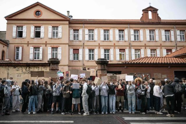 Protesters hold placards during a blockade of private high-school Emilie de Rodat in Toulouse, on October 8, 2026, as part of a nationwide protest movement over learning conditions. Since late September, pupils have barred the entrances to hundreds of schools, complaining of teacher absences, overloaded timetables, dilapidated classrooms and buildings ill-adapted to rising temperatures, among other grievances. (Photo by Lionel BONAVENTURE / AFP)