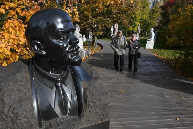 People walk past a sculpture featuring the founder of the Soviet Union Vladimir Lenin at the Muzeon park of Arts in Moscow on October 8, 2026. (Photo by Igor IVANKO / AFP)
