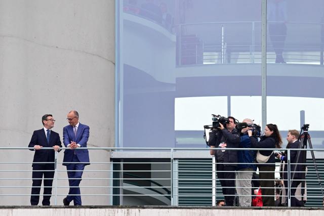 German Chancellor Friedrich Merz speaks with British Prime Minister Andy Burnham (L) on the balcony of the Chancellery in Berlin on October 8, 2026. (Photo by John MACDOUGALL / AFP)