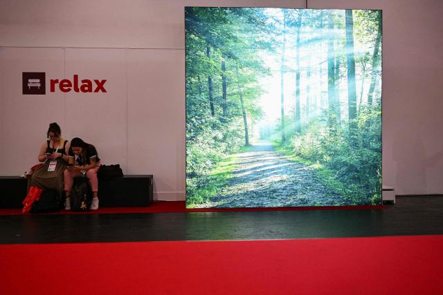 Visitors take a break sitting on a bench at the 78th Frankfurt book fair, the world's biggest trade fair for books, in Frankfurt am Main, western Germany on October 8, 2026. From October 7 to 11, 2026, publishing experts will meet up with partners from the technology and creative industries such as film and games at one of the world’s leading venues for printed and digital content with the Czech republic as guest of honour. (Photo by Kirill KUDRYAVTSEV / AFP)