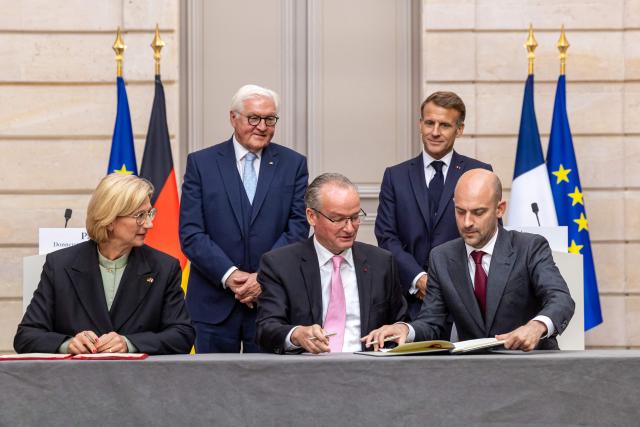 French President Emmanuel Macron (2nd R) and German President Frank-Walter Steinmeier (2-L) watch as Saarland's State Premier Anke Rehlinger (L), German Minister of State for Europe Gunther Krichbaum (C) and French Minister for Europe and Foreign Affairs Jean-Noel Barrot (R) sign agreements during a signing ceremony at the Elysee Palace in Paris, on October 8, 2026. The German president is on a two-day state visit to France. (Photo by Christophe PETIT TESSON / POOL / AFP)