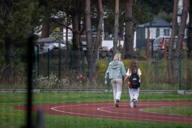A mother and her daughter leave the school grounds where a 15-year-old fatally stabbed the caretaker at the John-Paul II primary school in Leszczydol-Nowiny, Poland and wounded two other adults on October 8, 2026, a day after a similar knife attack wounded nine in a Polish high school, police said. Police arrested the boy after the attack at the John-Paul II primary school in Leszczydol-Nowiny, a small town 70 kilometres (40 miles) northeast of Warsaw, a police spokesperson told AFP. (Photo by Wojtek RADWANSKI / AFP)