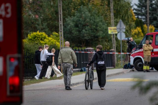 Parents and children leave the school grounds where a 15-year-old fatally stabbed the caretaker at the John-Paul II primary school in Leszczydol-Nowiny, Poland and wounded two other adults on October 8, 2026, a day after a similar knife attack wounded nine in a Polish high school, police said. Police arrested the boy after the attack at the John-Paul II primary school in Leszczydol-Nowiny, a small town 70 kilometres (40 miles) northeast of Warsaw, a police spokesperson told AFP. (Photo by Wojtek RADWANSKI / AFP)