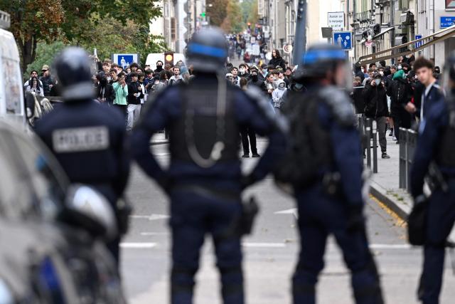 French police officers face protesters during a student demonstration in Nancy, eastern France, on October 8, 2026, as part of a nationwide protest movement over learning conditions. Since late September, pupils have barred the entrances to hundreds of schools, complaining of teacher absences, overloaded timetables, dilapidated classrooms and buildings ill-adapted to rising temperatures, among other grievances. (Photo by Jean-Christophe VERHAEGEN / AFP)