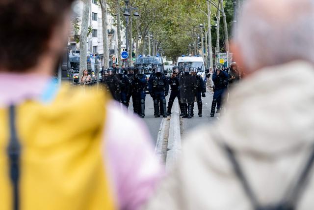 Parents of students and teachers stand between the students and the police at the end of the student protest in Marseille on October 8, 2026. Since late September, pupils have barred the entrances to hundreds of schools, complaining of teacher absences, overloaded timetables, dilapidated classrooms and buildings ill-adapted to rising temperatures, among other grievances. (Photo by Miguel MEDINA / AFP)