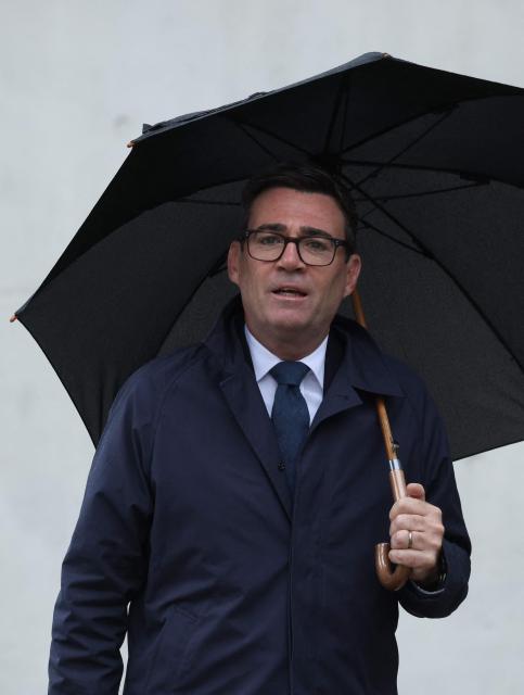 British Prime Minister Andy Burnham holds an umbrella as he arrives for a tv interview following his meeting with the German Chancellor in Berlin on October 8, 2026 . (Photo by Sean GALLUP / POOL / AFP)