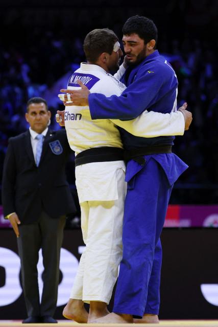 Serbia's Nemanja Majdov (white) and Azerbaijan's Murad Fatiyev embrace each other after the men's under 90 kg bronze medal bout at the World Judo Championships in Baku on October 8, 2026. (Photo by Anne-Christine POUJOULAT / AFP)