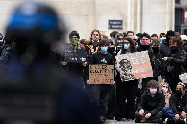 A protester hold placard (C) reading "Studying in decent conditions is not a luxury" in front of police during a student demonstration in Nancy, eastern France, on October 8, 2026, as part of a nationwide protest movement over learning conditions. Since late September, pupils have barred the entrances to hundreds of schools, complaining of teacher absences, overloaded timetables, dilapidated classrooms and buildings ill-adapted to rising temperatures, among other grievances. (Photo by Jean-Christophe VERHAEGEN / AFP)