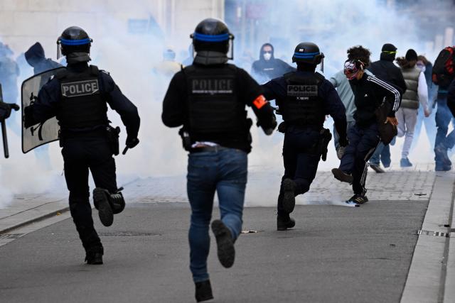 Police officers run towards protesters during a student demonstration in Nancy, eastern France, on October 8, 2026, as part of a nationwide protest movement over learning conditions. Since late September, pupils have barred the entrances to hundreds of schools, complaining of teacher absences, overloaded timetables, dilapidated classrooms and buildings ill-adapted to rising temperatures, among other grievances. (Photo by Jean-Christophe VERHAEGEN / AFP)