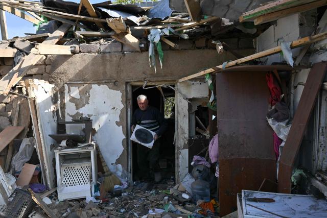 Owners, their relatives and neighbours collect belongings from a destroyed private house following an attack, which local Russian-installed officials called a Ukrainian drone strike, in Donetsk, Russian-controlled Ukraine, on October 8, 2026, amid the ongoing Russian-Ukrainian conflict. (Photo by AFP)