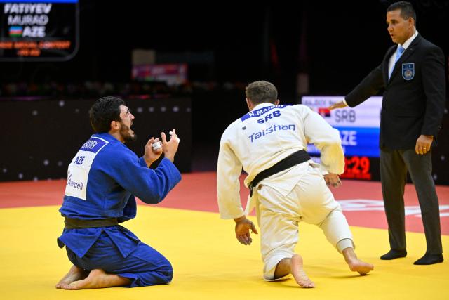 Azerbaijan's Murad Fatiyev (blue) reacts after defeating Serbia's Nemanja Majdov in the men's under 90 kg bronze medal bout at the World Judo Championships in Baku on October 8, 2026. (Photo by Alexander NEMENOV / AFP)